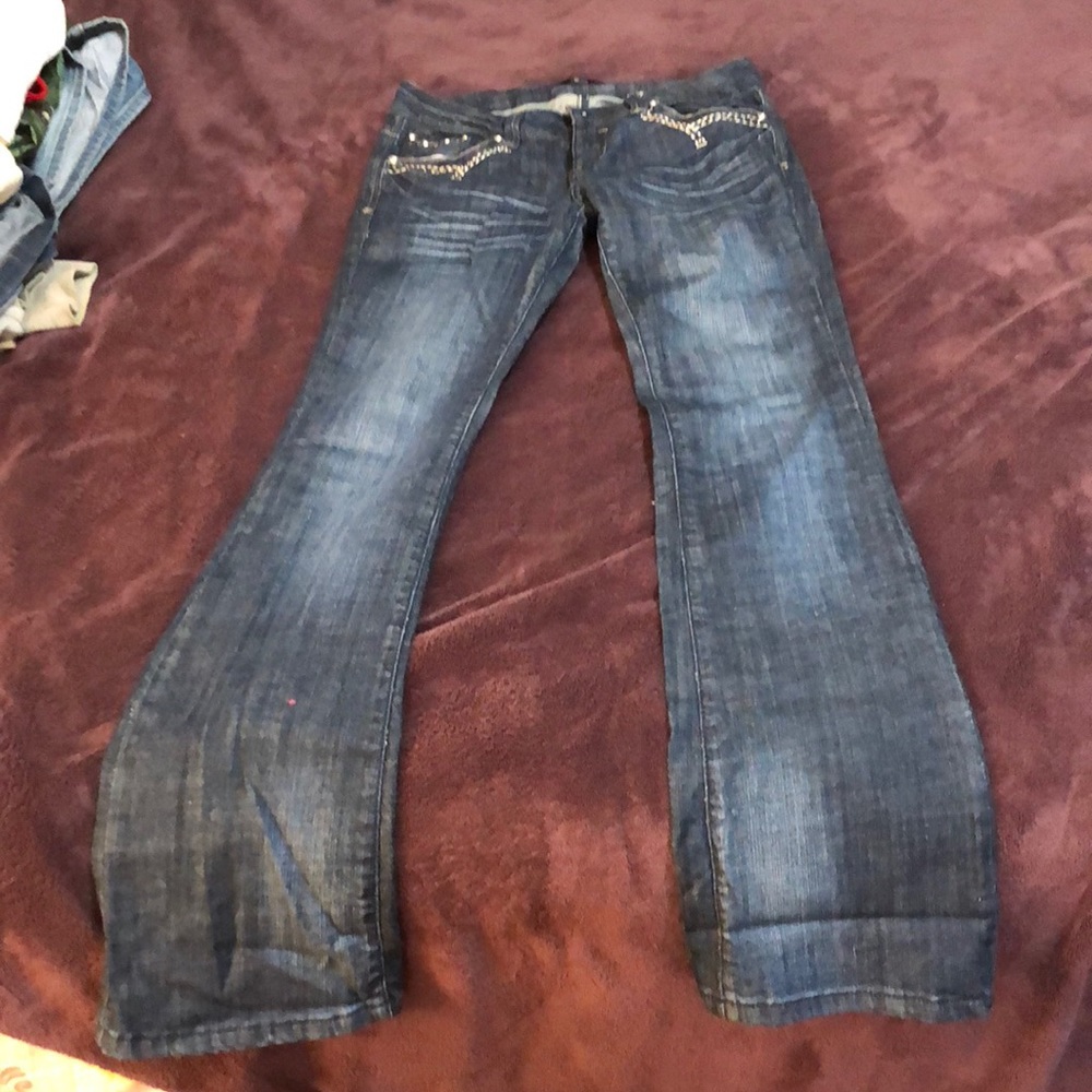 Dark denim jeans with jeweled patterned pockets.